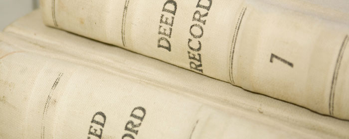 Cloth-bound deed record volumes on a shelf